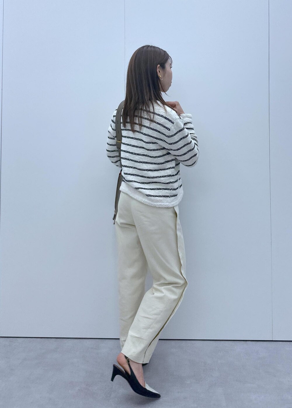 ブラック系のパンプス、ホワイト系のノーカラージャケット、オレンジ系のTシャツ/カットソーを着用したレディースの冬コーディネートの2枚目の写真