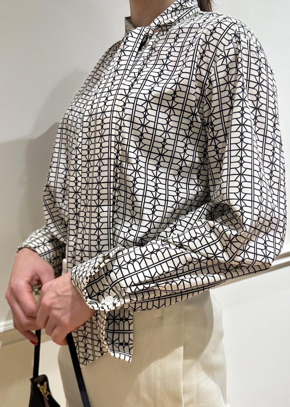 ブラック系のハンドバッグ、ホワイト系のシャツ/ブラウス、ホワイト系のその他パンツを着用したレディースの冬コーディネートの4枚目の写真