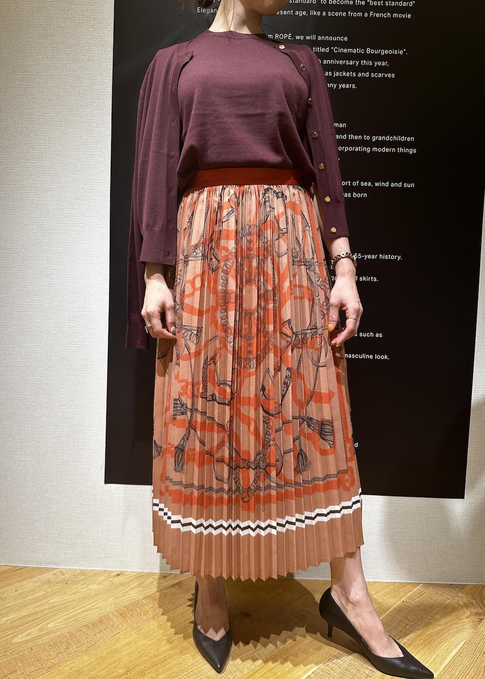 ベージュ系のパンプス、レッド系のニット/セーター、レッド系のカーディガン/ボレロを着用したレディースの夏コーディネートの2枚目の写真