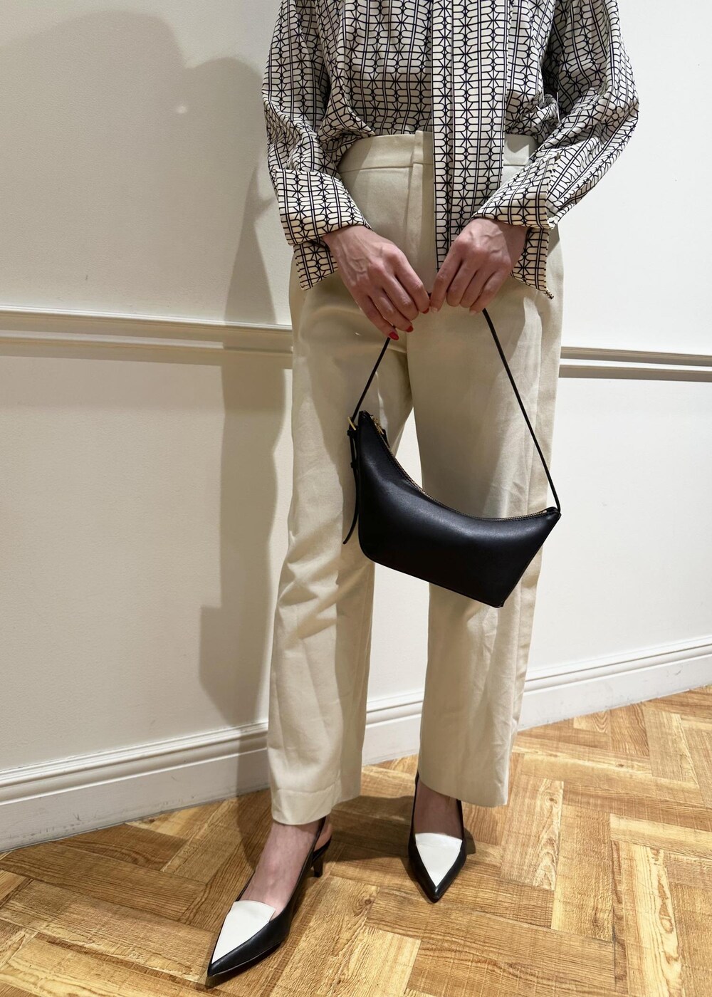 ブラック系のハンドバッグ、ホワイト系のシャツ/ブラウス、ホワイト系のその他パンツを着用したレディースの冬コーディネートの3枚目の写真