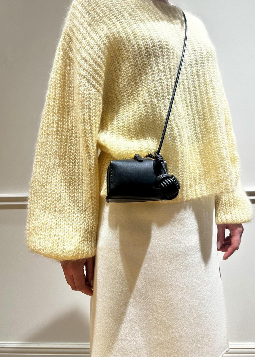 ホワイト系のスカート、イエロー系のニット/セーター、ホワイト系のTシャツ/カットソーを着用したレディースの冬コーディネートの5枚目の写真