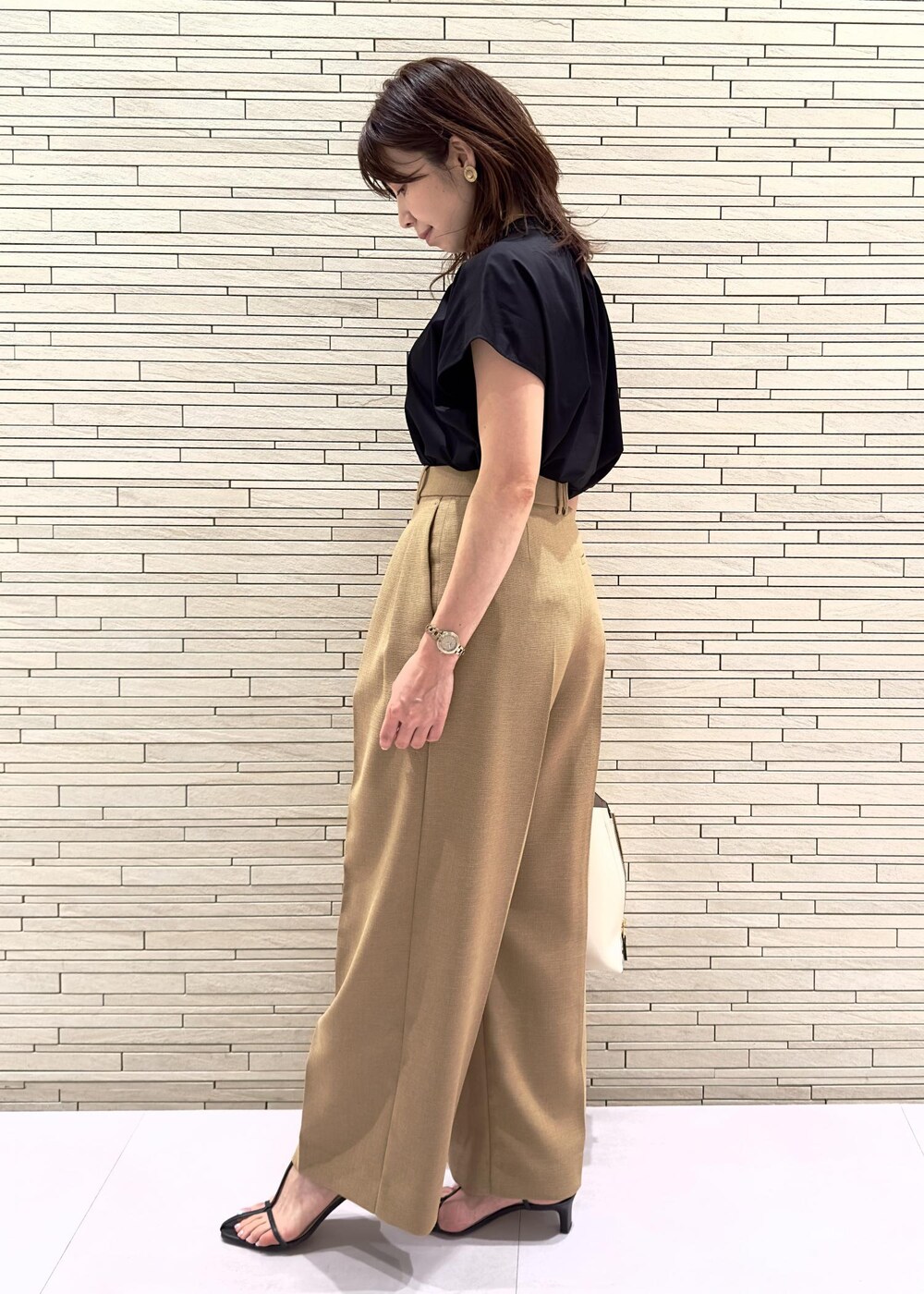 ホワイト系のハンドバッグ、ブラック系のサンダル、ベージュ系のその他パンツを着用したレディースの夏コーディネートの2枚目の写真