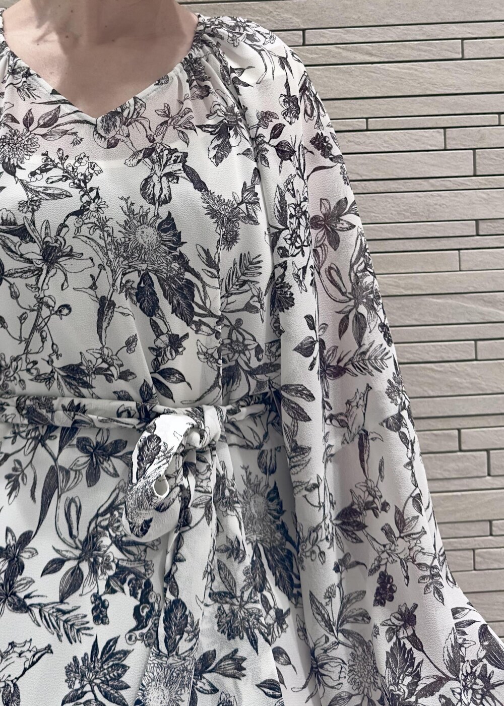 グリーン系のハンドバッグ、ブラック系のダウンジャケット/コート、ブラック系のワンピースを着用したレディースの冬コーディネートの8枚目の写真