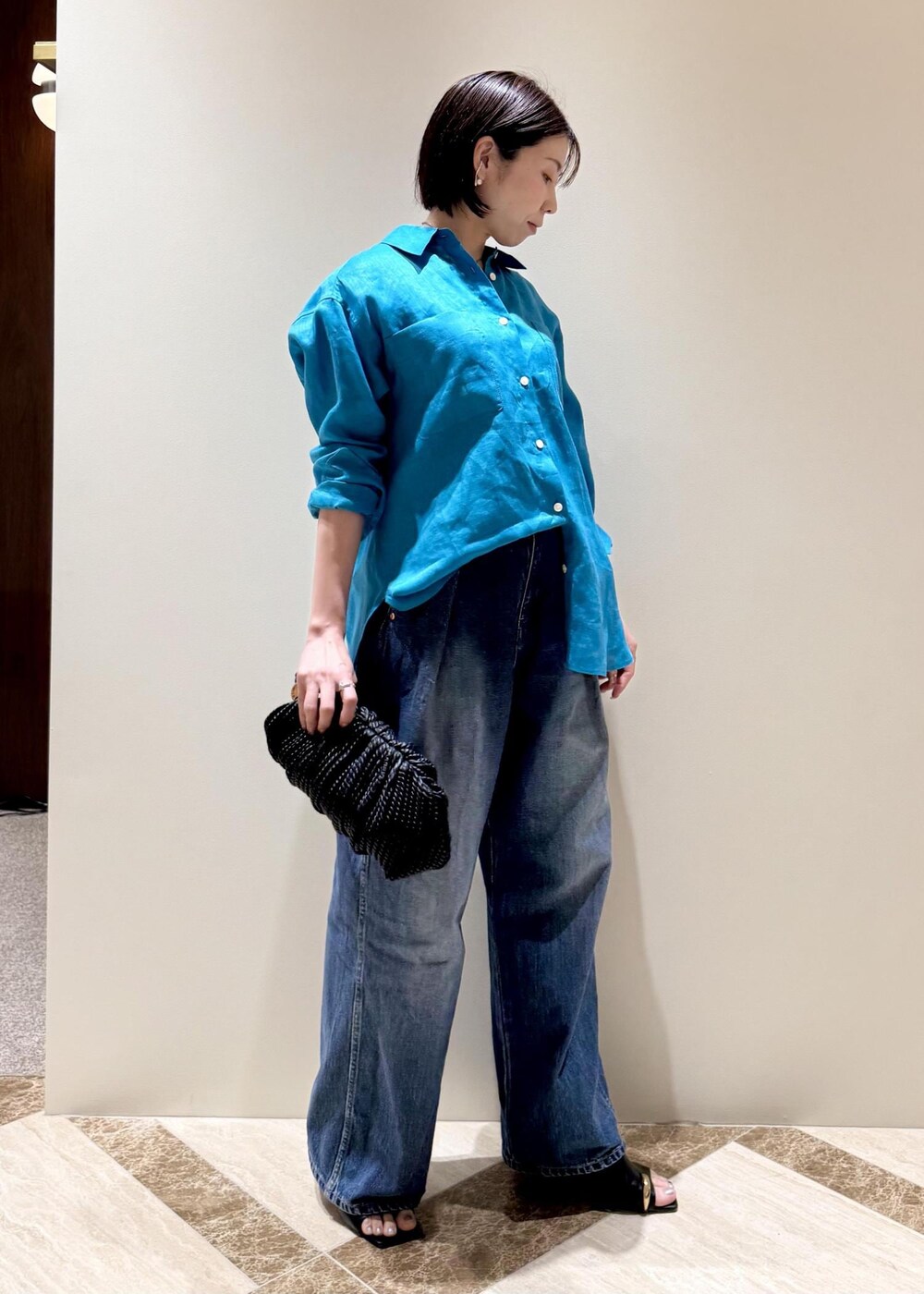 ブルー系のデニムパンツ、ブラック系のサンダル、ブルー系のシャツ/ブラウスを着用したレディースの春コーディネートの2枚目の写真