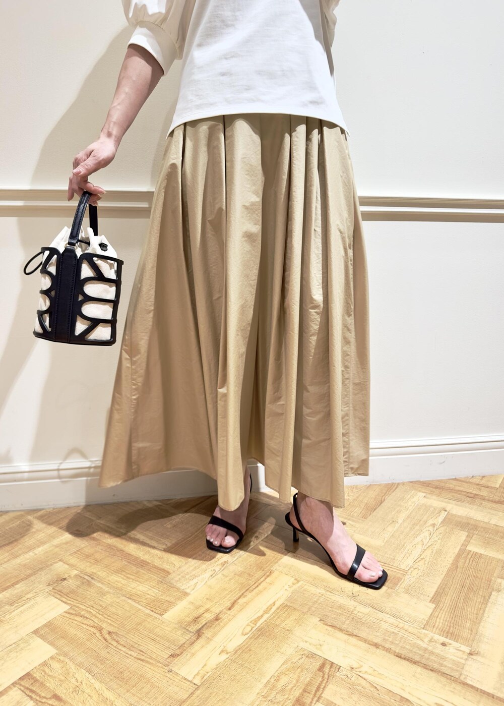 ブラック系のサンダル、ベージュ系のスカート、ホワイト系のTシャツ/カットソーを着用したレディースの夏コーディネートの7枚目の写真