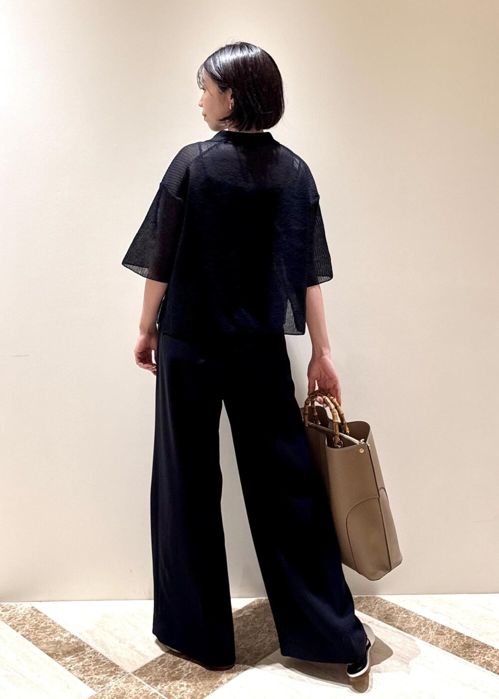 ベージュ系のトートバッグ、シルバー系のパンプス、ブラック系のカーディガン/ボレロを着用したレディースの夏コーディネートの3枚目の写真