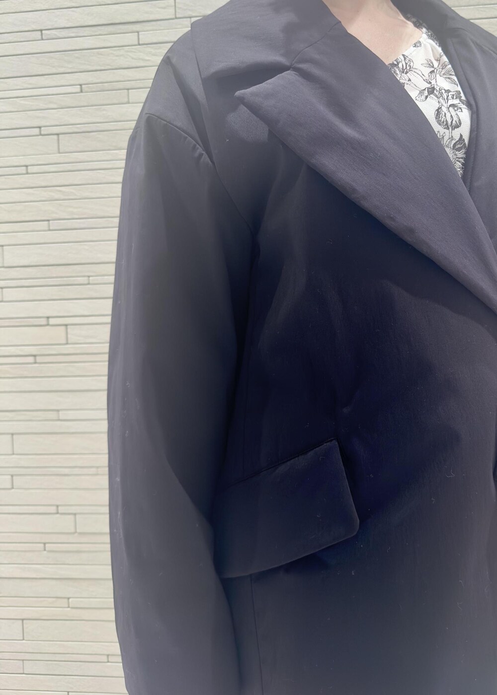 グリーン系のハンドバッグ、ブラック系のダウンジャケット/コート、ブラック系のワンピースを着用したレディースの冬コーディネートの4枚目の写真