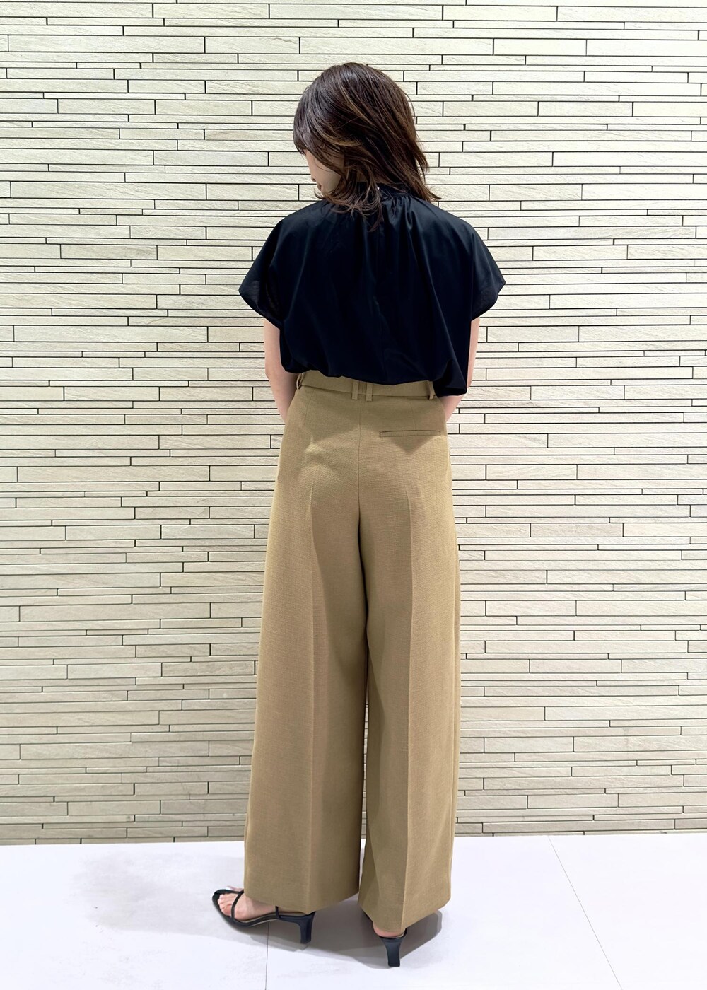 ホワイト系のハンドバッグ、ブラック系のサンダル、ベージュ系のその他パンツを着用したレディースの夏コーディネートの3枚目の写真