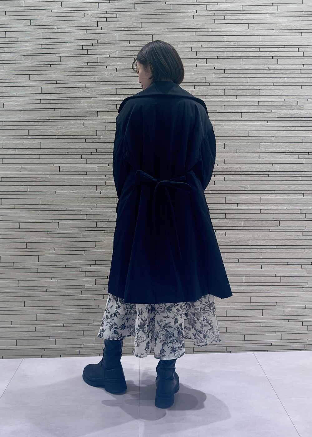 グリーン系のハンドバッグ、ブラック系のダウンジャケット/コート、ブラック系のワンピースを着用したレディースの冬コーディネートの3枚目の写真