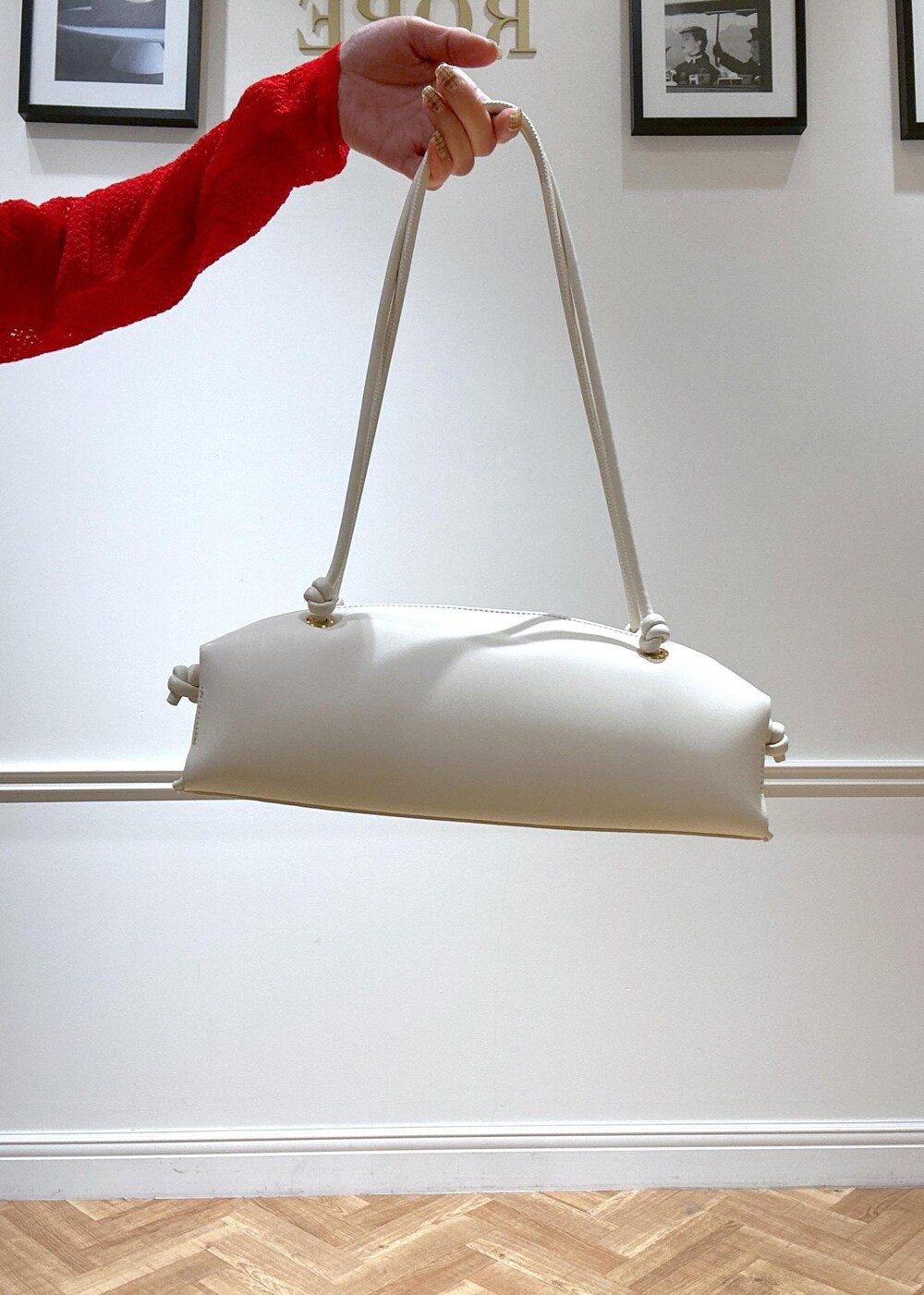 ブラック系のパンプス、ホワイト系のハンドバッグ、レッド系のカーディガン/ボレロを着用したレディースの冬コーディネートの7枚目の写真