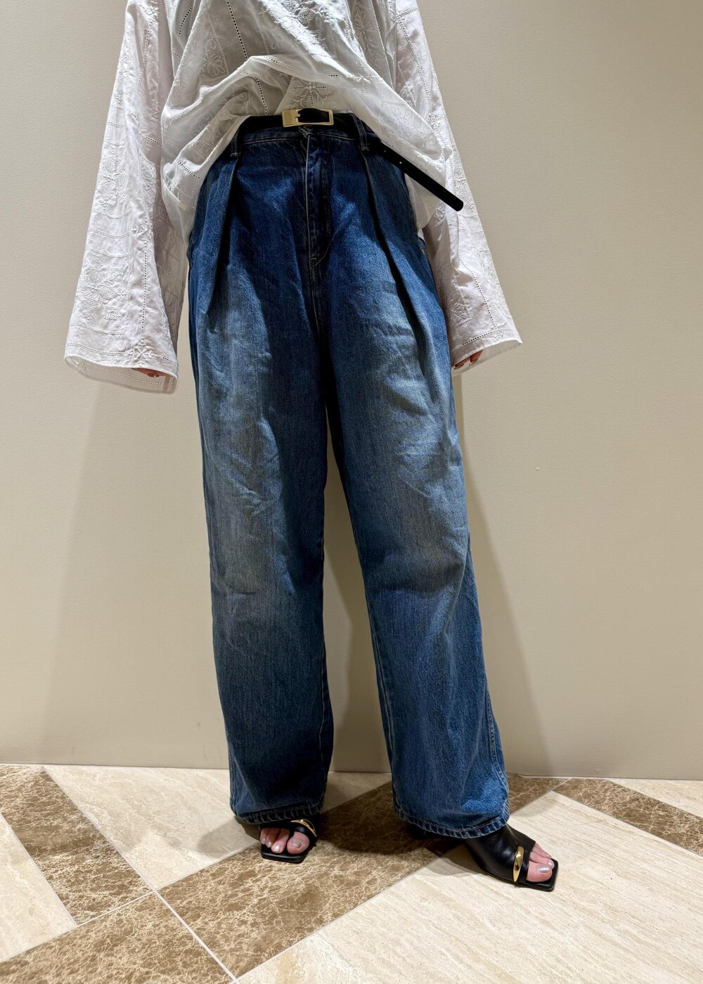 ブルー系のデニムパンツ、ブラック系のサンダル、ホワイト系のシャツ/ブラウスを着用したレディースの春コーディネートの6枚目の写真