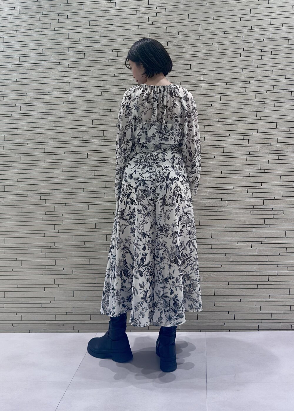 グリーン系のハンドバッグ、ブラック系のダウンジャケット/コート、ブラック系のワンピースを着用したレディースの冬コーディネートの7枚目の写真