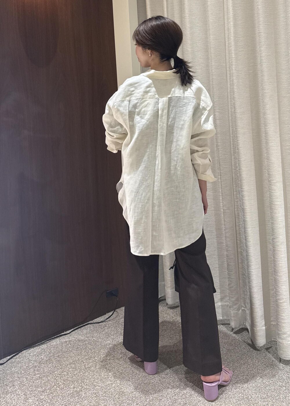 ホワイト系のシャツ/ブラウス、ブラック系のハンドバッグ、ブラウン系のTシャツ/カットソーを着用したレディースの春コーディネートの3枚目の写真