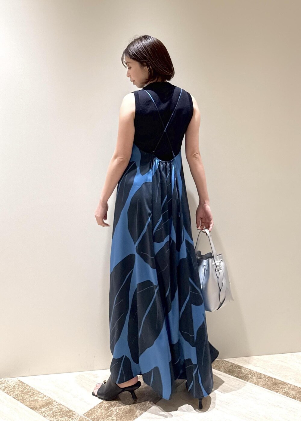 ブラック系のサンダル、シルバー系のショルダーバッグ、ブルー系のワンピースを着用したレディースの春コーディネートの3枚目の写真