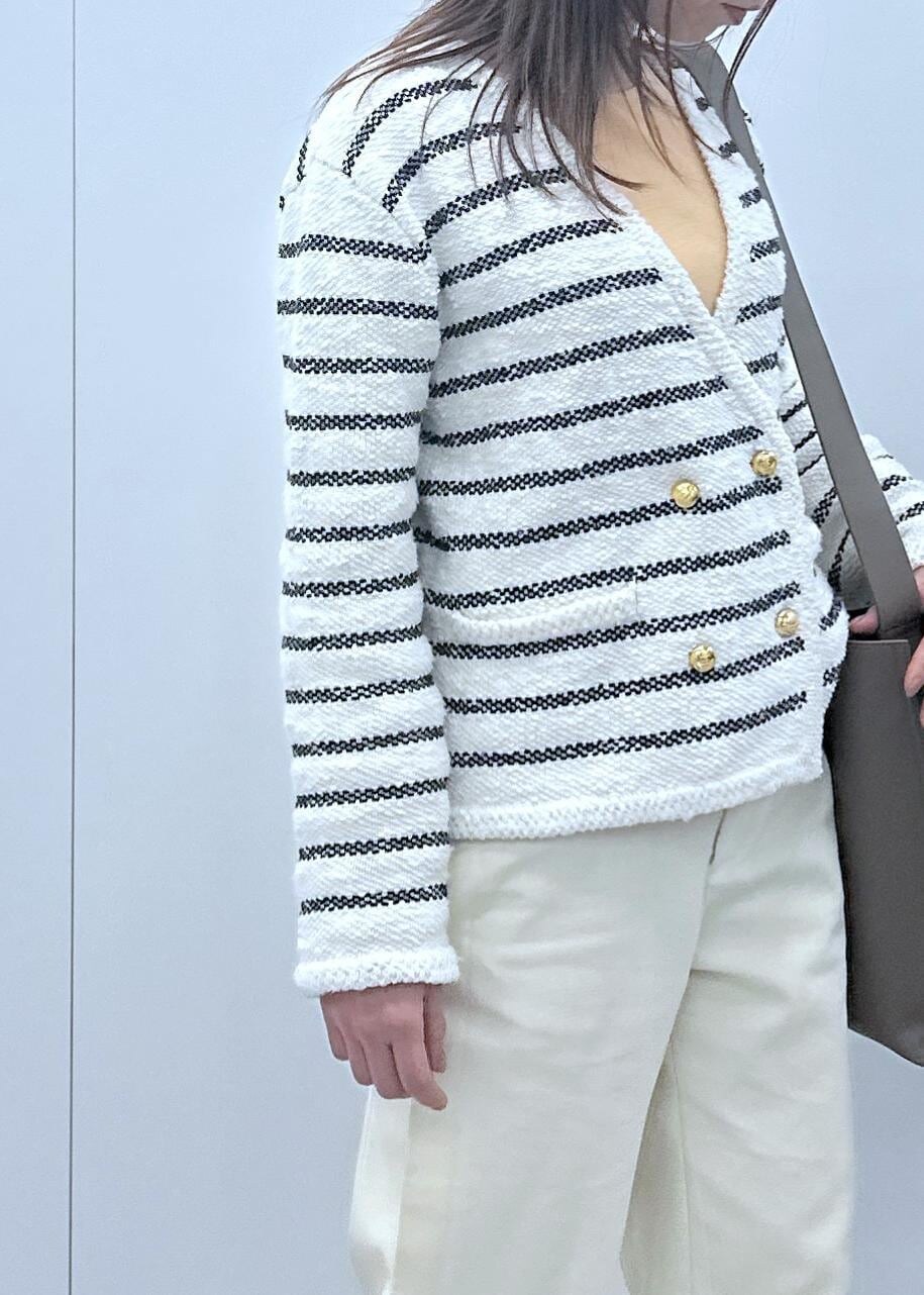 ブラック系のパンプス、ホワイト系のノーカラージャケット、オレンジ系のTシャツ/カットソーを着用したレディースの冬コーディネートの4枚目の写真