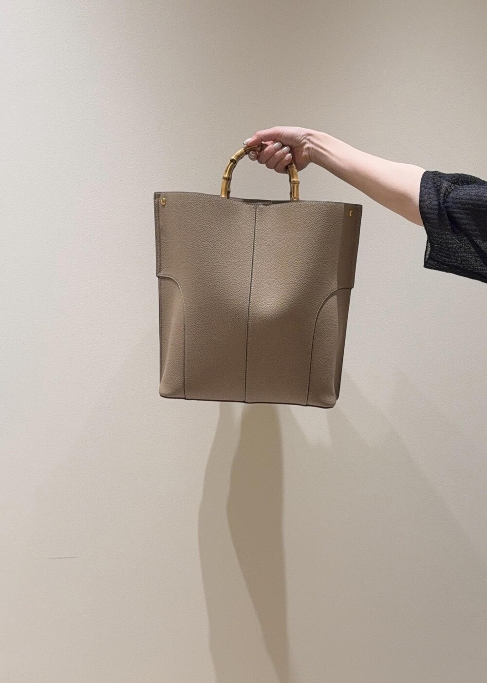 ベージュ系のトートバッグ、シルバー系のパンプス、ブラック系のカーディガン/ボレロを着用したレディースの夏コーディネートの6枚目の写真