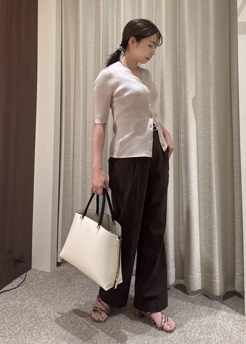 ホワイト系のトートバッグ、ピンク系のカーディガン/ボレロ、ブラウン系のその他パンツを着用したレディースの夏コーディネートの2枚目の写真