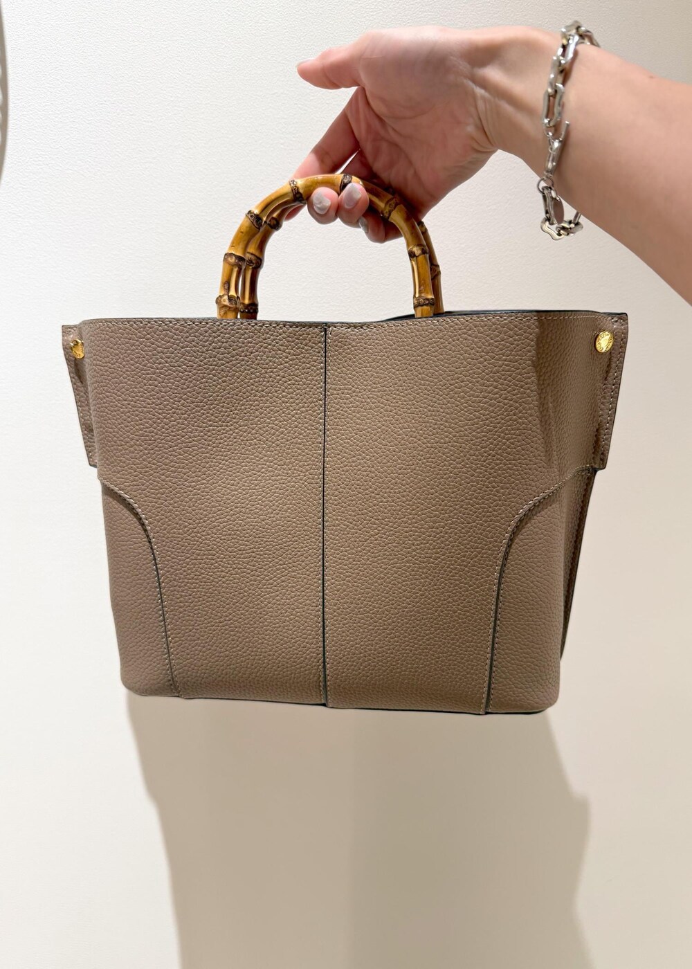 ブラック系のスカート、レッド系のTシャツ/カットソー、ベージュ系のハンドバッグを着用したレディースの夏コーディネートの6枚目の写真