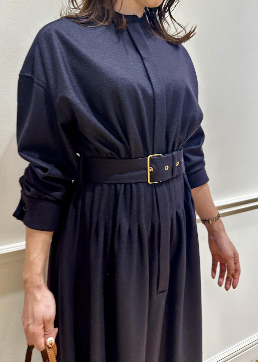 ブラウン系のショルダーバッグ、ホワイト系のブーツ、ブルー系のワンピースを着用したレディースの冬コーディネートの4枚目の写真