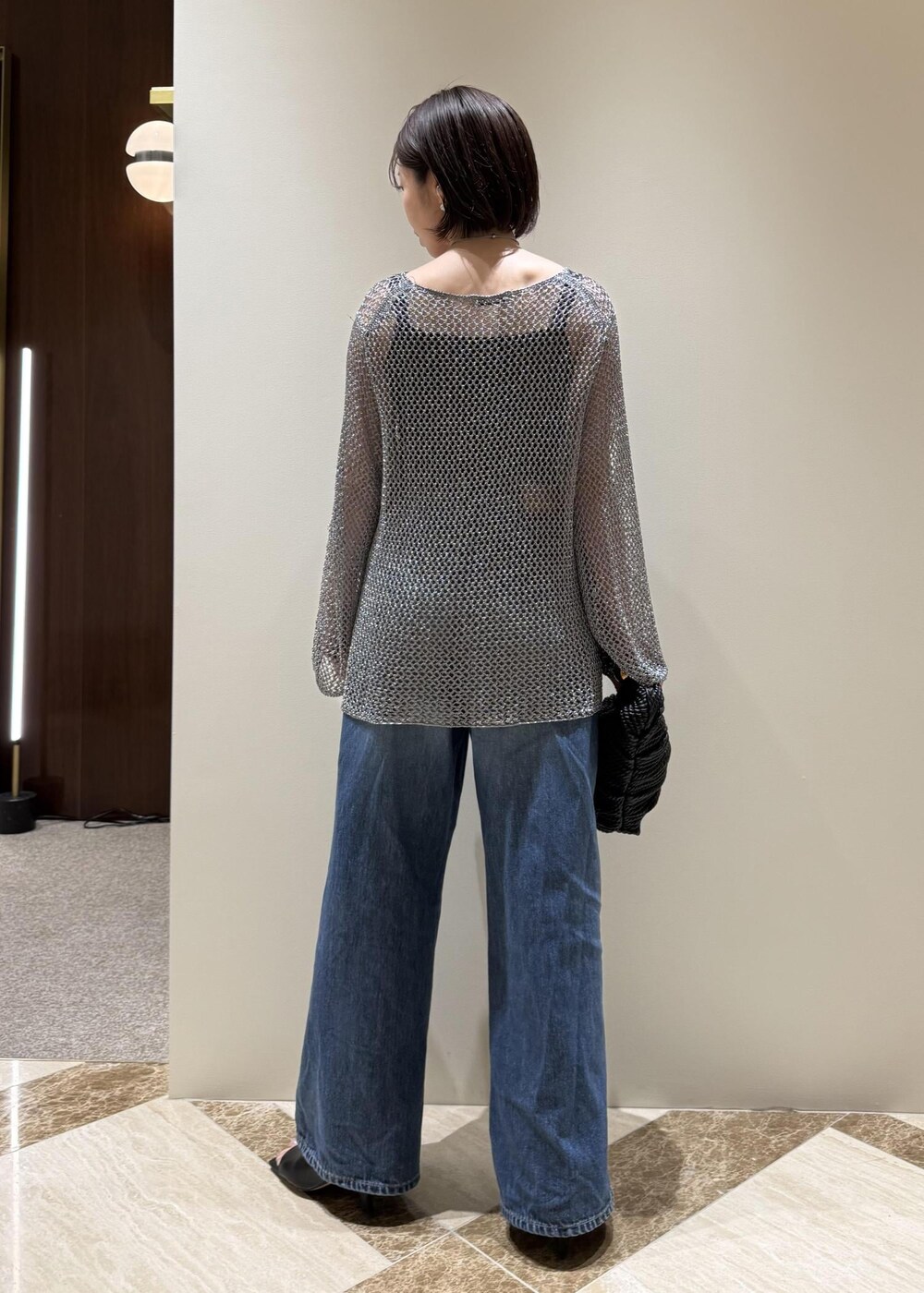 ブルー系のデニムパンツ、ブラック系のサンダル、シルバー系のその他トップスを着用したレディースの春コーディネートの3枚目の写真