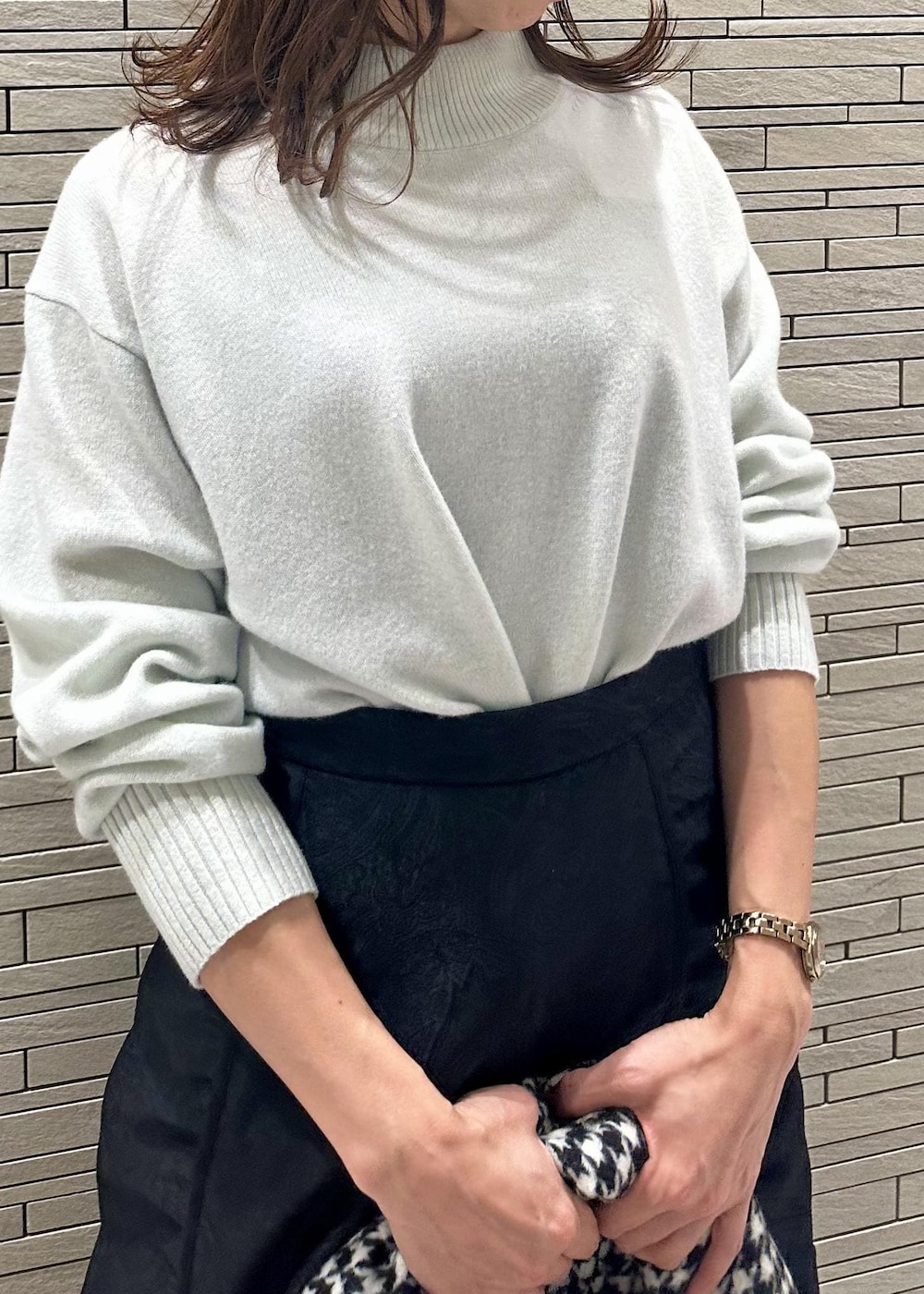 ホワイト系のブーツ、ベージュ系のショルダーバッグ、グリーン系のニット/セーターを着用したレディースの冬コーディネートの4枚目の写真