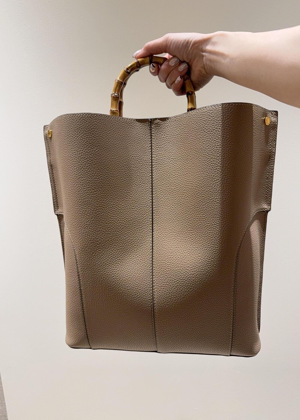 ブラック系のパンプス、ブルー系のワンピース、ベージュ系のトートバッグを着用したレディースの夏コーディネートの8枚目の写真