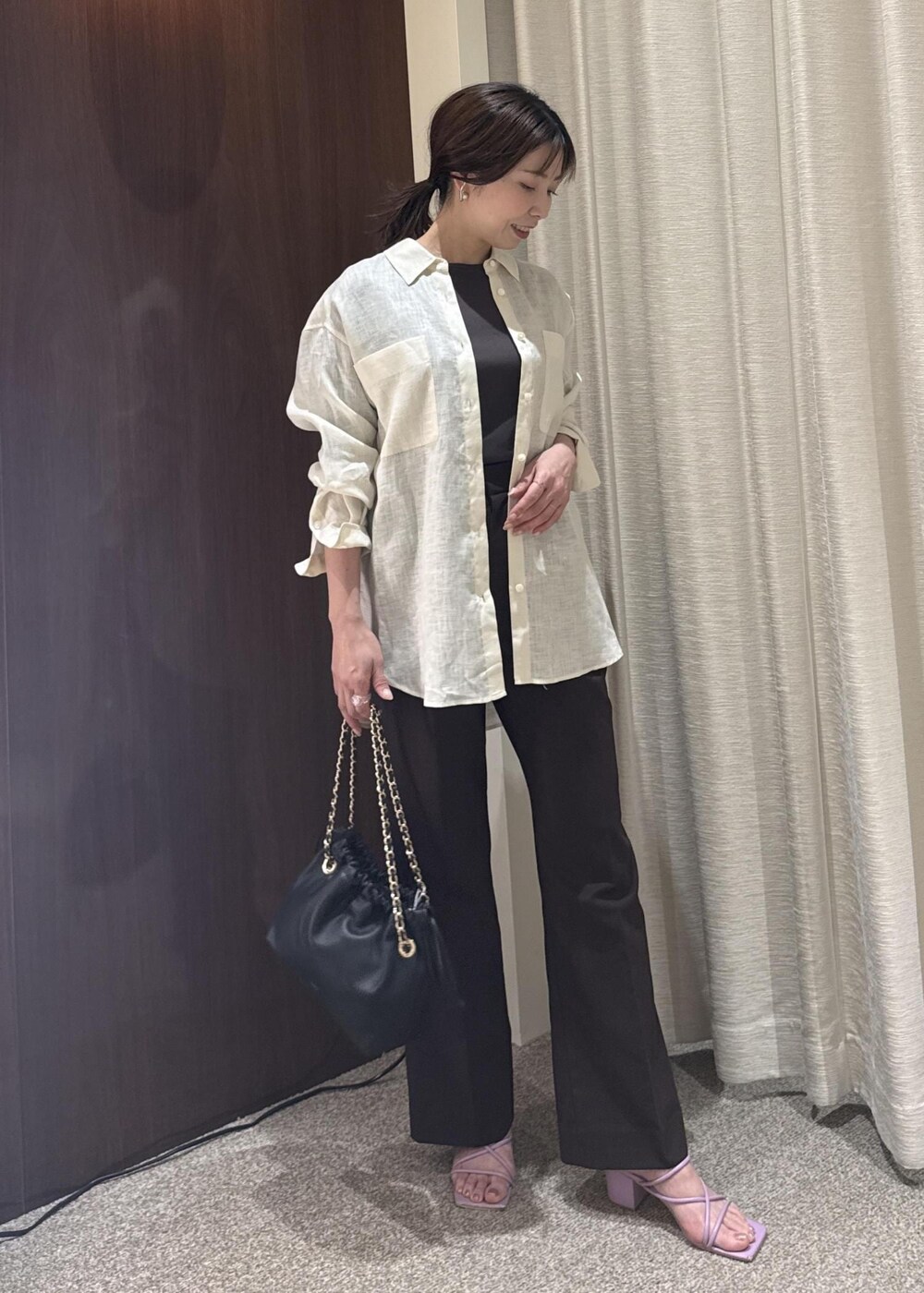 ホワイト系のシャツ/ブラウス、ブラック系のハンドバッグ、ブラウン系のTシャツ/カットソーを着用したレディースの春コーディネートの2枚目の写真