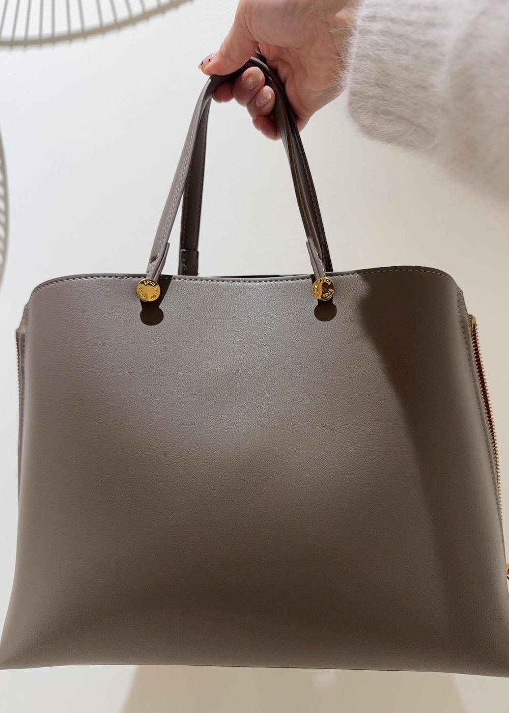 ブラウン系のトートバッグ、ブラック系のブーツ、ブラック系のスカートを着用したレディースの冬コーディネートの7枚目の写真