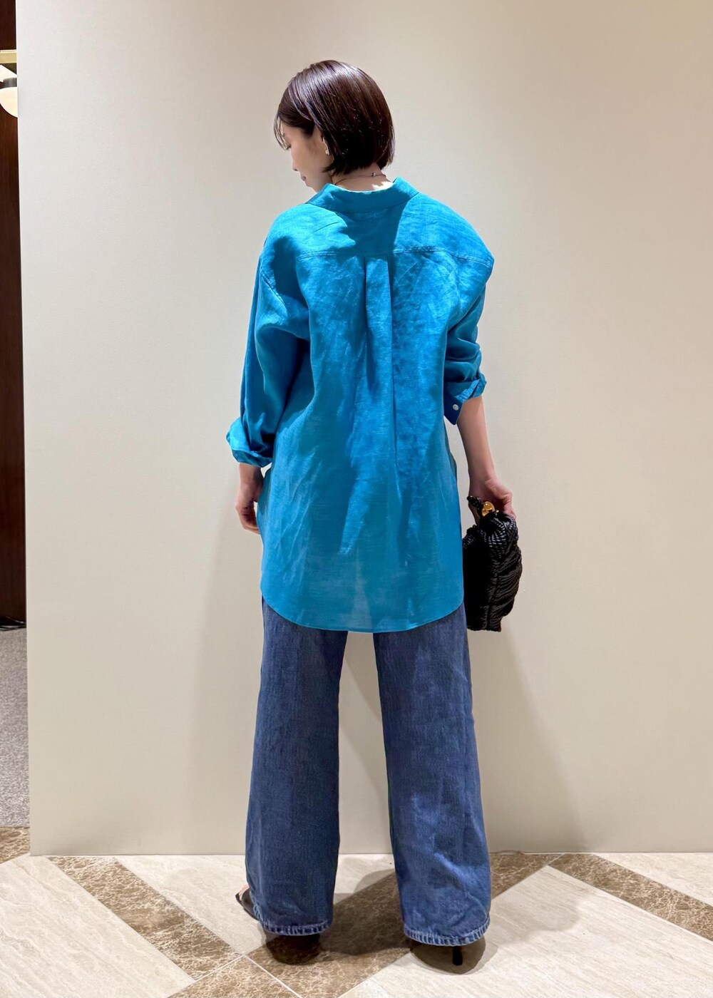 ブルー系のデニムパンツ、ブラック系のサンダル、ブルー系のシャツ/ブラウスを着用したレディースの春コーディネートの3枚目の写真