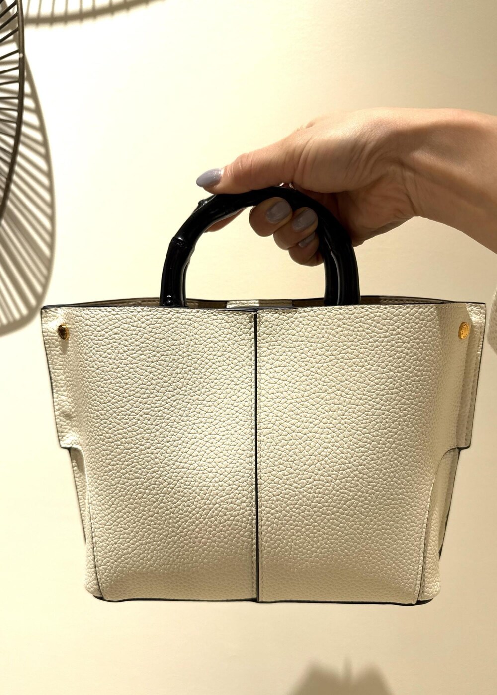 ブラック系のブーツ、ホワイト系のハンドバッグを着用したレディースの冬コーディネートの6枚目の写真