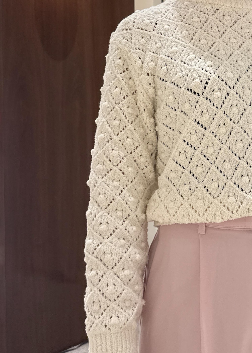 ブラック系のブーツ、ブラック系のハンドバッグ、ホワイト系のニット/セーターを着用したレディースの冬コーディネートの5枚目の写真