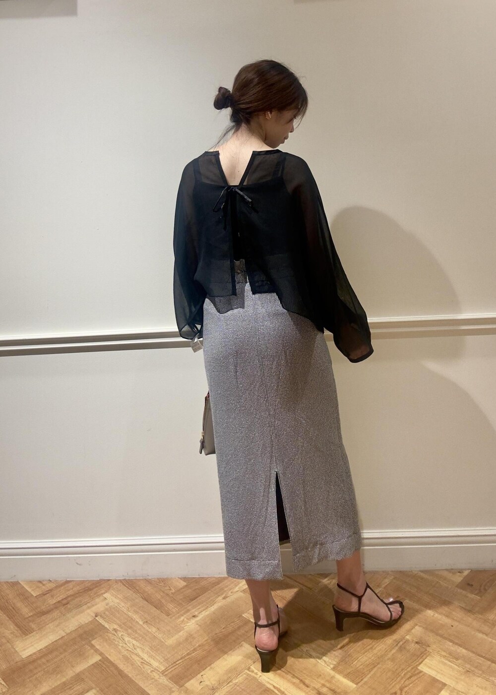 ブラウン系のハンドバッグ、ブラック系のスカート、ブラック系のシャツ/ブラウスを着用したレディースの春コーディネートの3枚目の写真