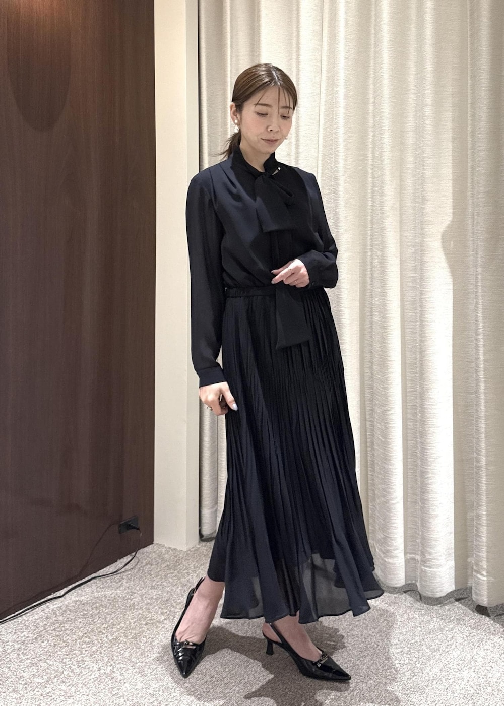 ブルー系のワンピース、グレー系のハンドバッグ、ブルー系のノーカラージャケットを着用したレディースの冬コーディネートの4枚目の写真