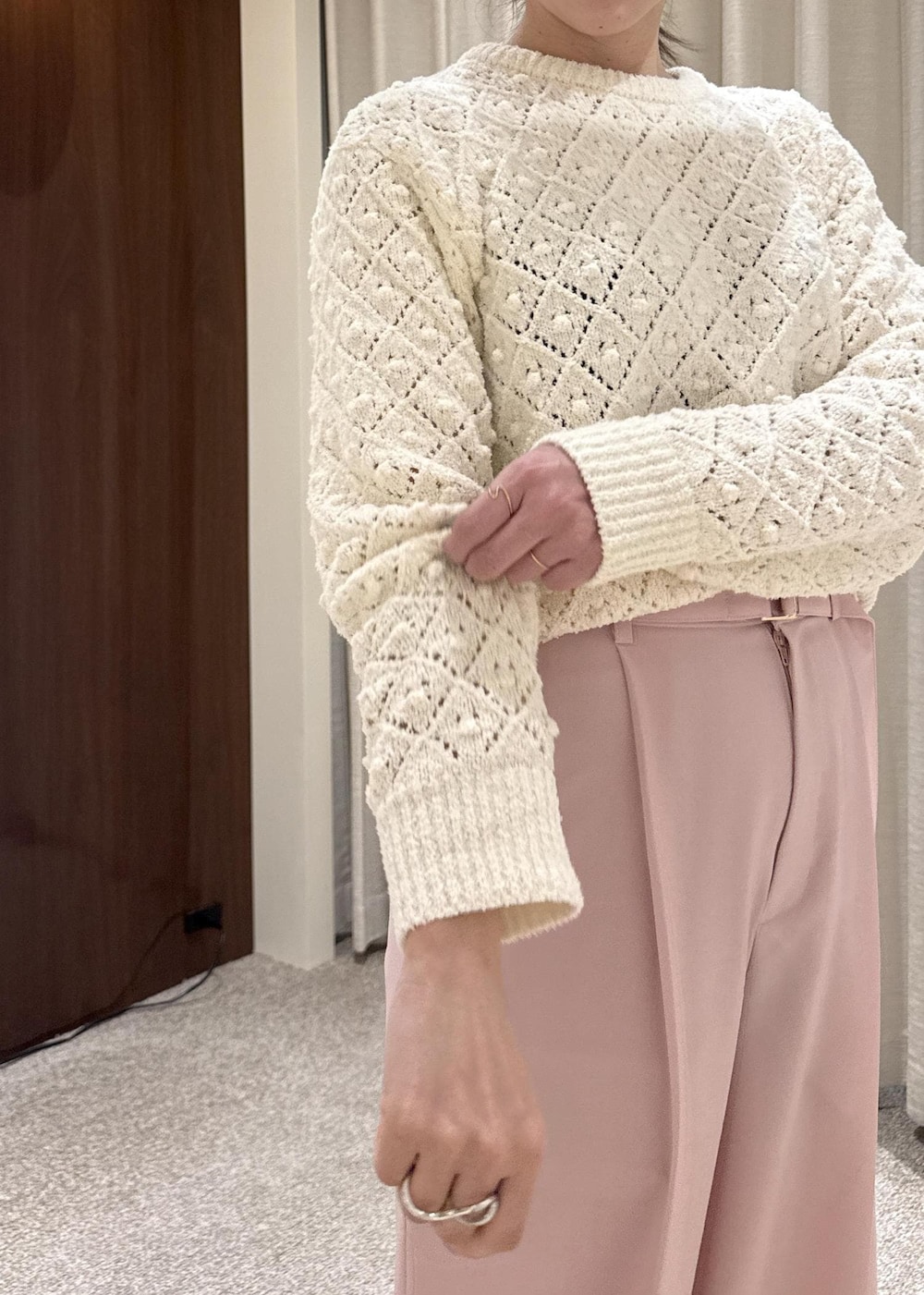 ブラック系のブーツ、ブラック系のハンドバッグ、ホワイト系のニット/セーターを着用したレディースの冬コーディネートの4枚目の写真