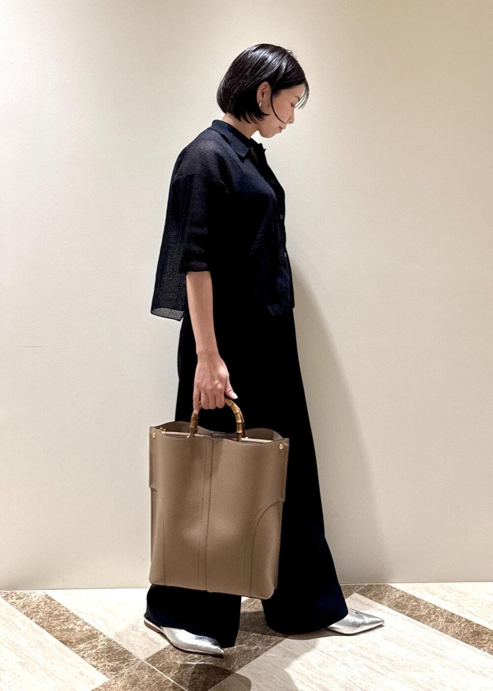 ベージュ系のトートバッグ、シルバー系のパンプス、ブラック系のカーディガン/ボレロを着用したレディースの夏コーディネートの2枚目の写真