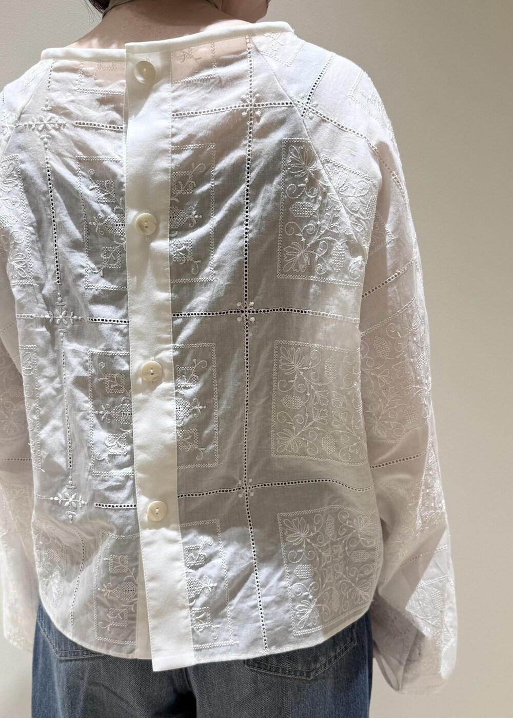 ブルー系のデニムパンツ、ブラック系のサンダル、ホワイト系のシャツ/ブラウスを着用したレディースの春コーディネートの5枚目の写真