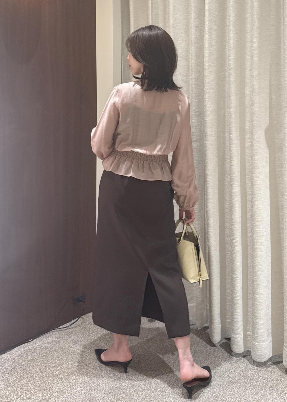 ベージュ系のハンドバッグ、ブラウン系のスカート、ピンク系のシャツ/ブラウスを着用したレディースの春コーディネートの3枚目の写真