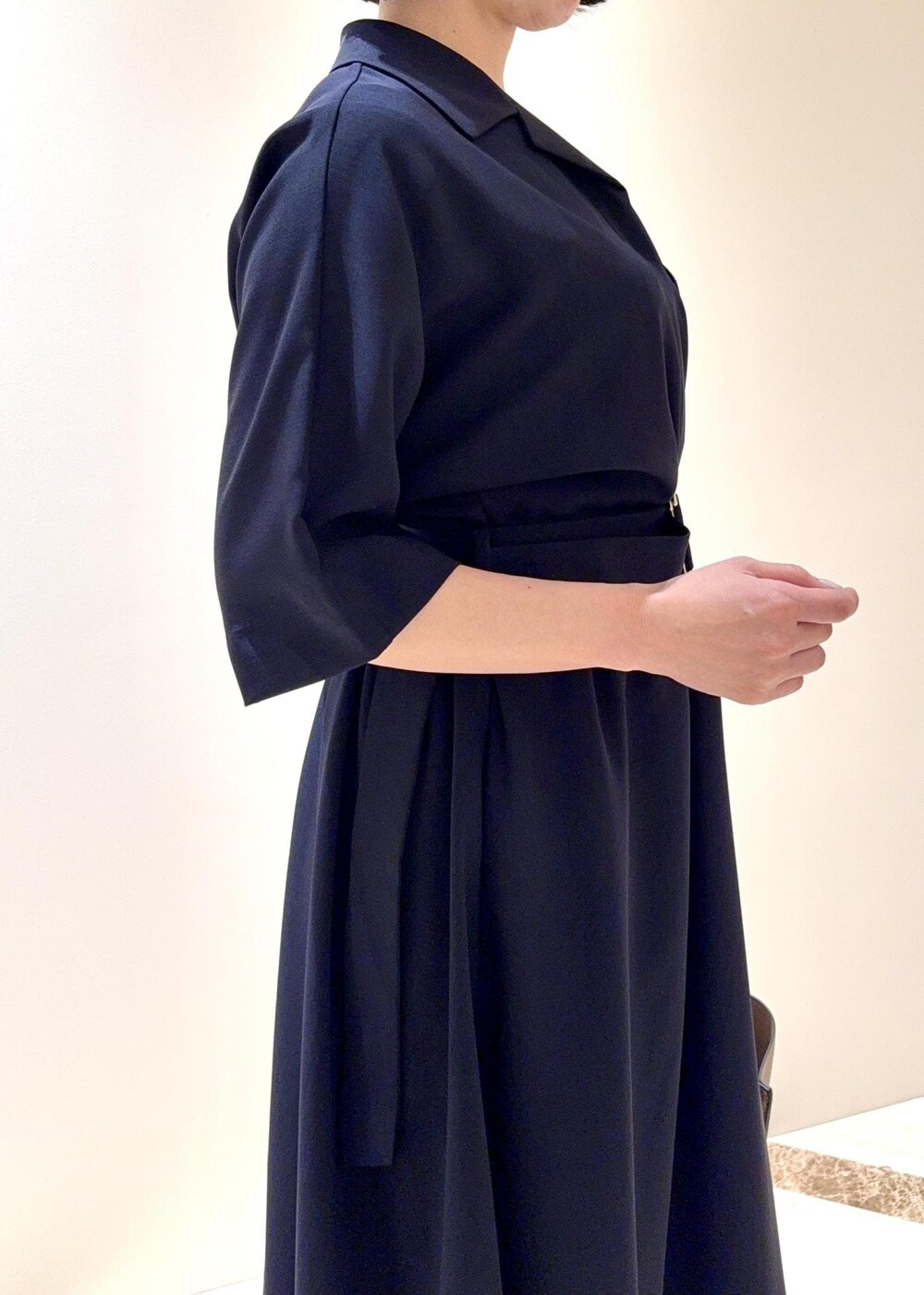 ブラック系のパンプス、ブルー系のワンピース、ベージュ系のトートバッグを着用したレディースの夏コーディネートの4枚目の写真