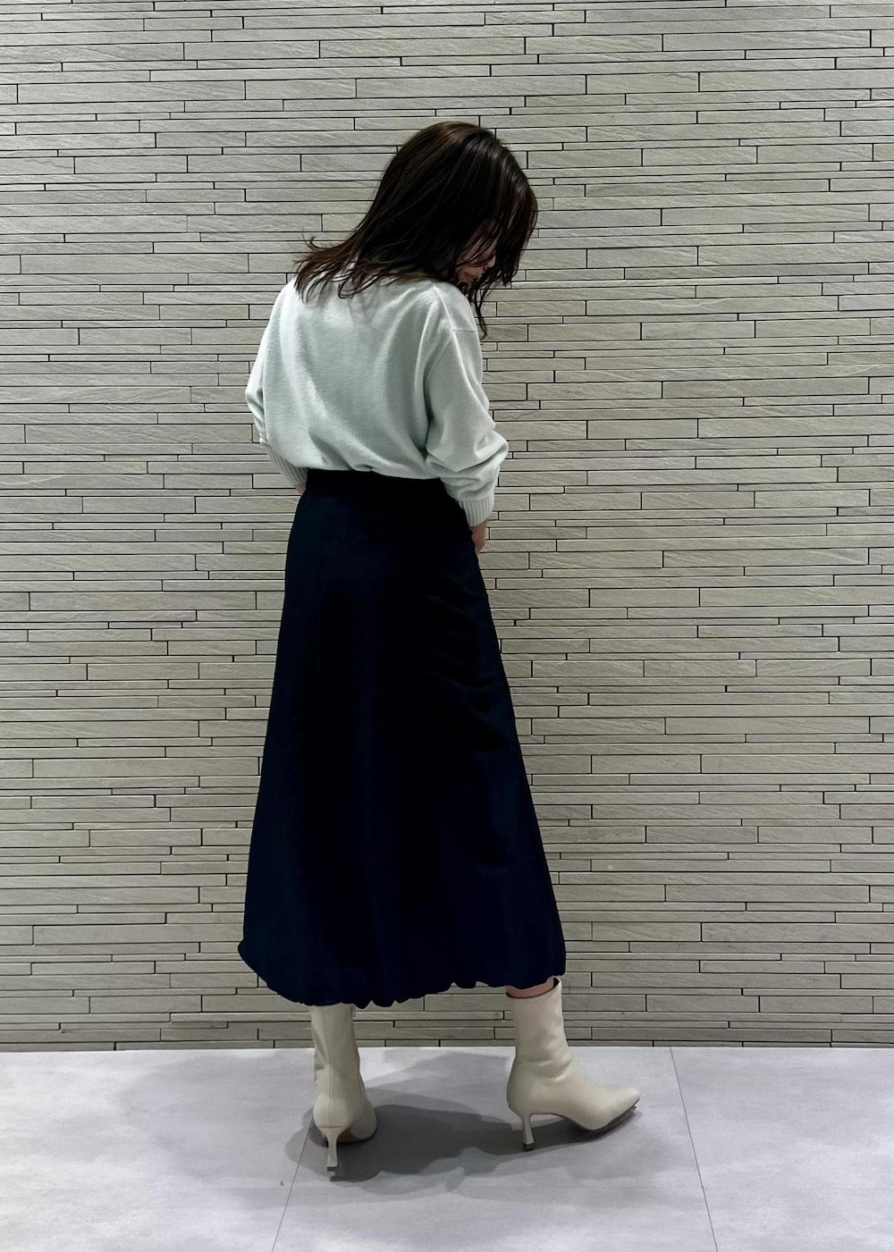 ホワイト系のブーツ、ベージュ系のショルダーバッグ、グリーン系のニット/セーターを着用したレディースの冬コーディネートの3枚目の写真