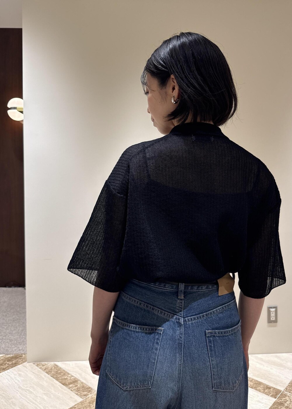 ブルー系のデニムパンツ、シルバー系のパンプス、ブラック系のカーディガン/ボレロを着用したレディースの夏コーディネートの4枚目の写真