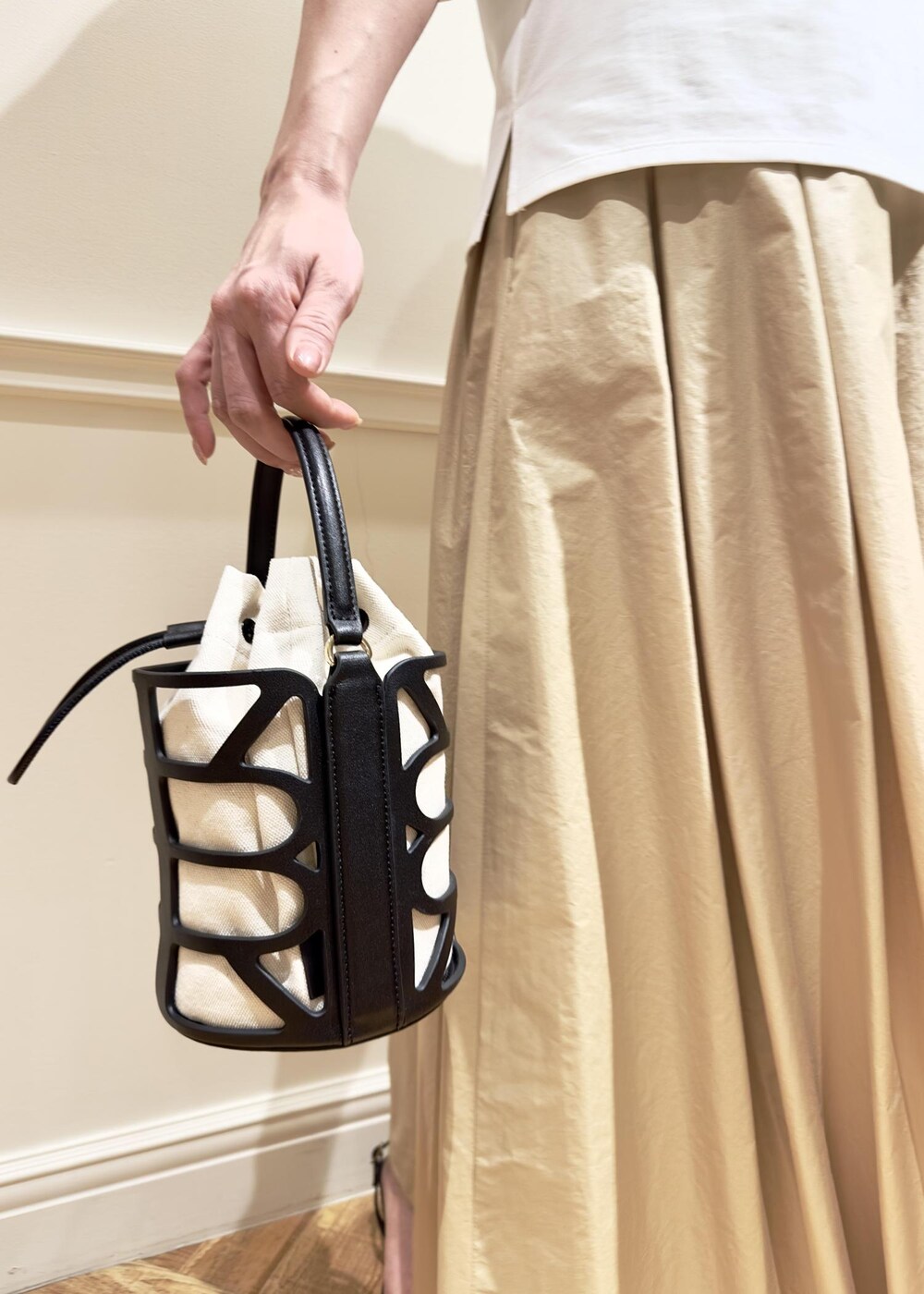 ブラック系のサンダル、ベージュ系のスカート、ホワイト系のTシャツ/カットソーを着用したレディースの夏コーディネートの6枚目の写真