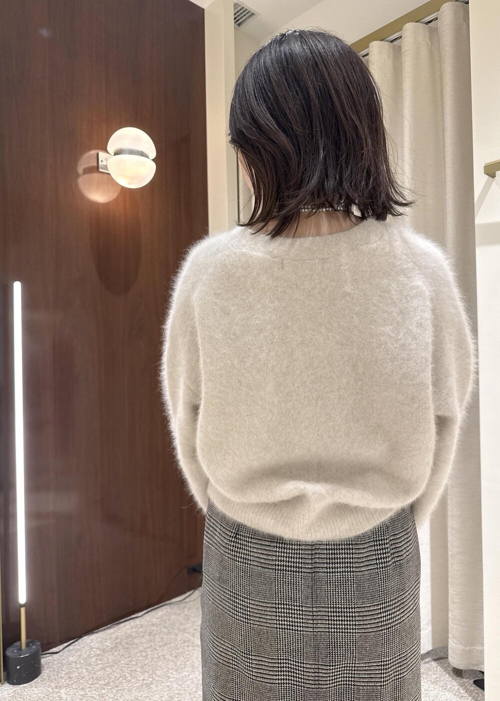 ブラウン系のトートバッグ、ブラック系のブーツ、ブラック系のスカートを着用したレディースの冬コーディネートの5枚目の写真