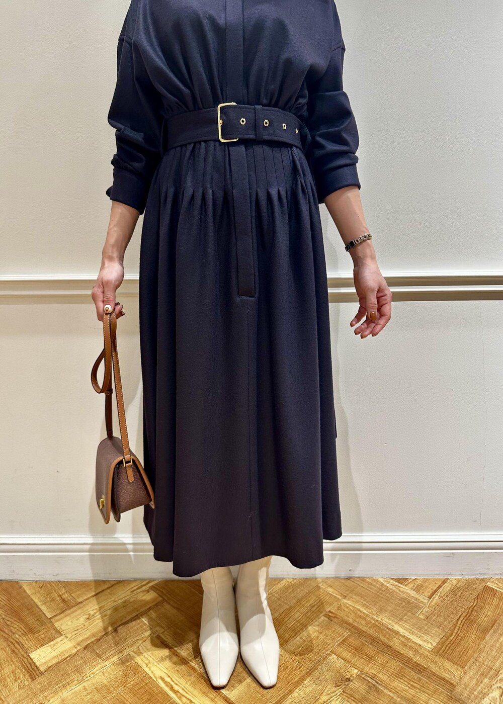 ブラウン系のショルダーバッグ、ホワイト系のブーツ、ブルー系のワンピースを着用したレディースの冬コーディネートの5枚目の写真