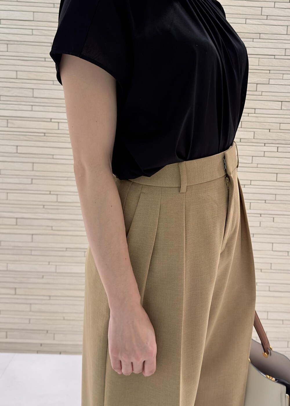 ホワイト系のハンドバッグ、ブラック系のサンダル、ベージュ系のその他パンツを着用したレディースの夏コーディネートの4枚目の写真