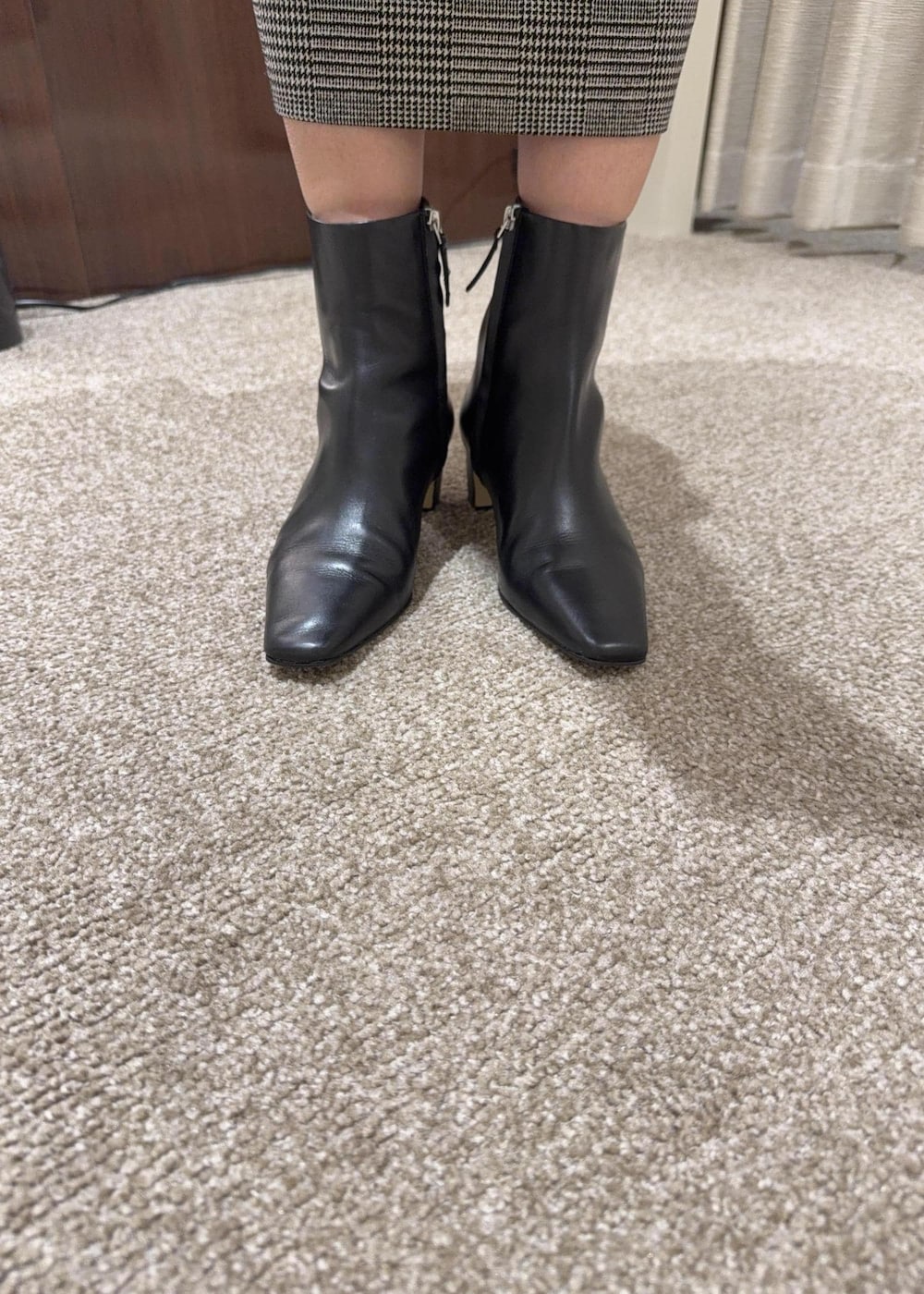 ブラウン系のトートバッグ、ブラック系のブーツ、ブラック系のスカートを着用したレディースの冬コーディネートの8枚目の写真