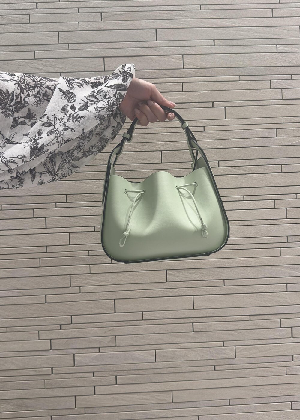 グリーン系のハンドバッグ、ブラック系のダウンジャケット/コート、ブラック系のワンピースを着用したレディースの冬コーディネートの9枚目の写真