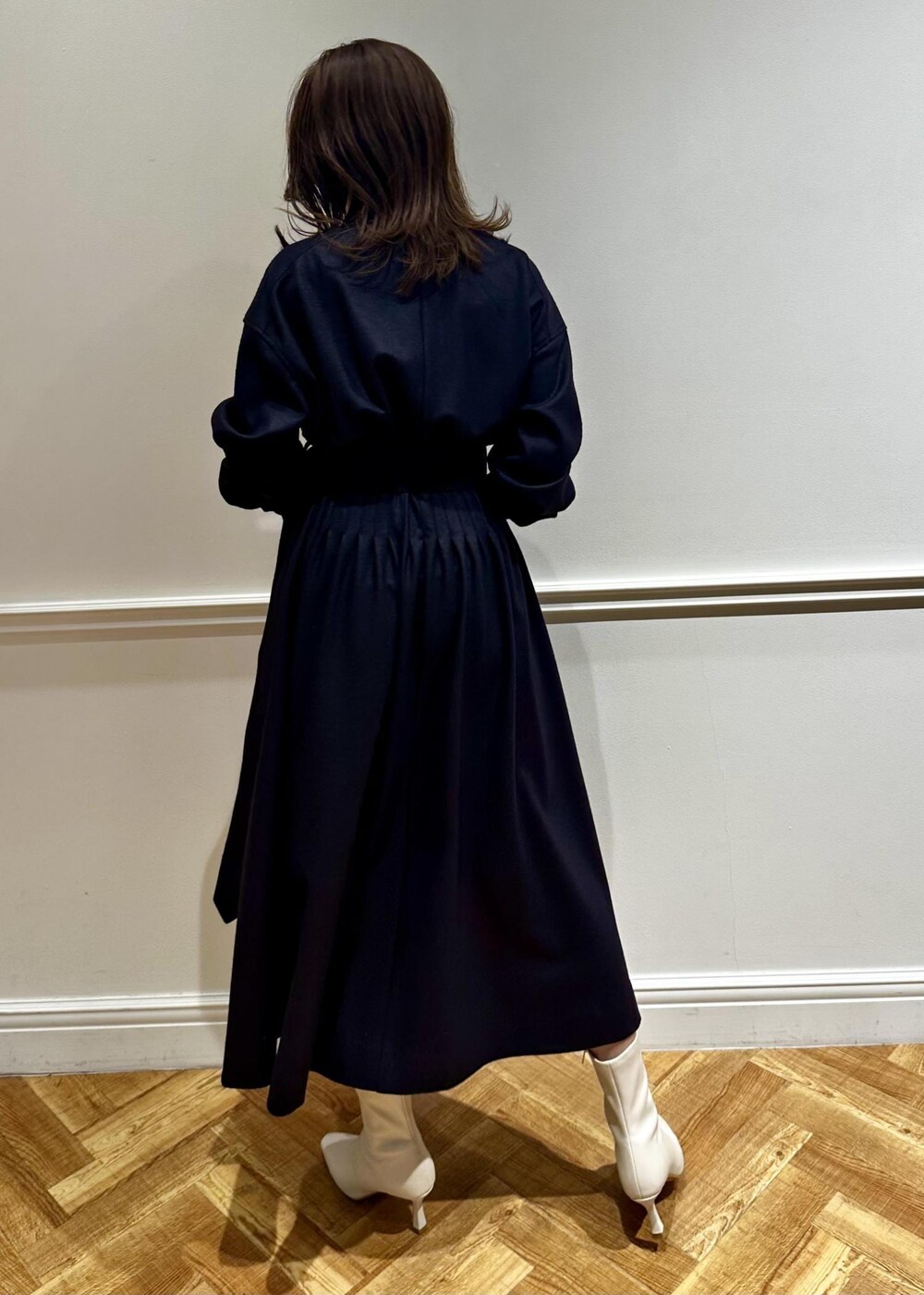 ブラウン系のショルダーバッグ、ホワイト系のブーツ、ブルー系のワンピースを着用したレディースの冬コーディネートの2枚目の写真