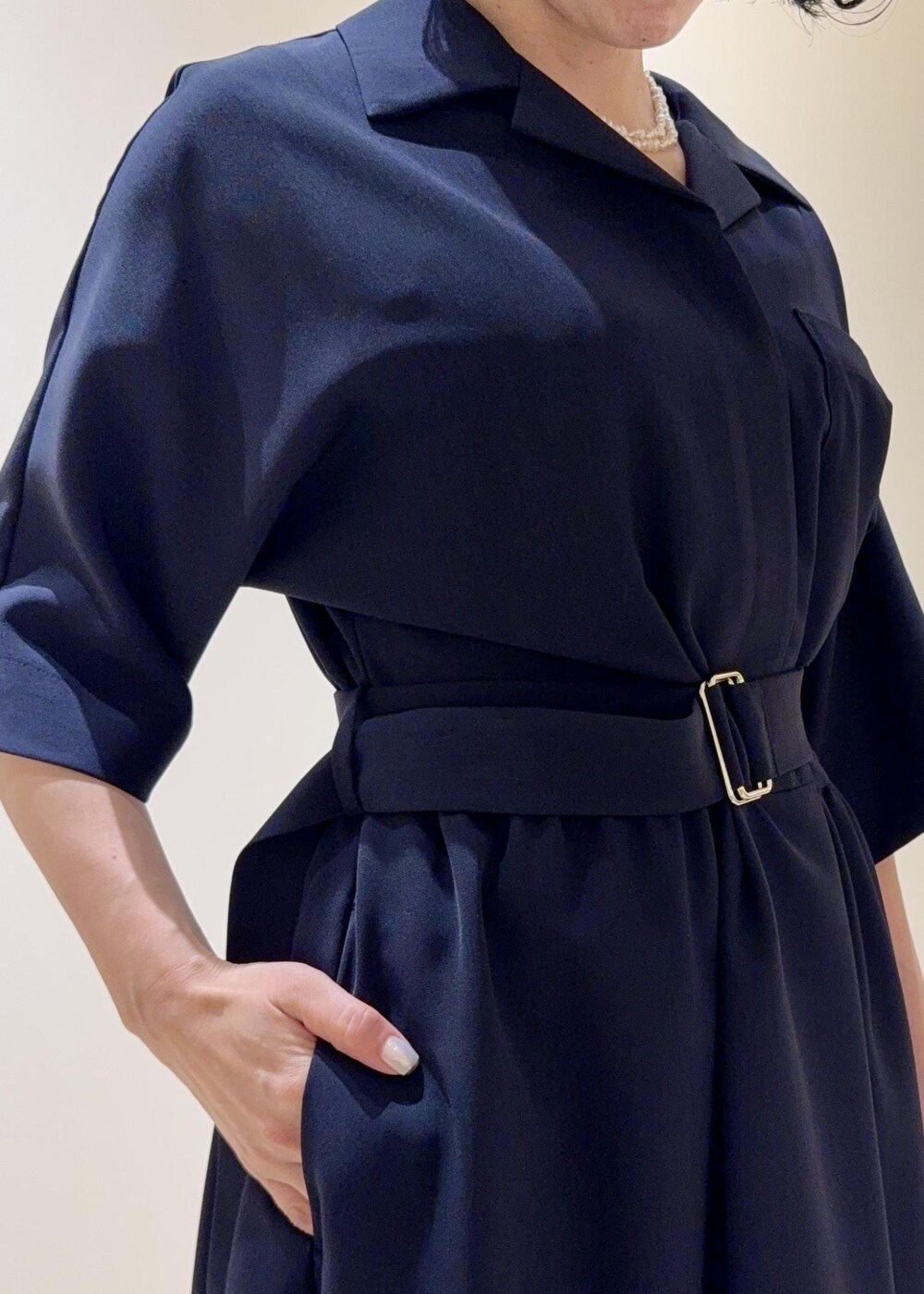 ブラック系のパンプス、ブルー系のワンピース、ベージュ系のトートバッグを着用したレディースの夏コーディネートの6枚目の写真