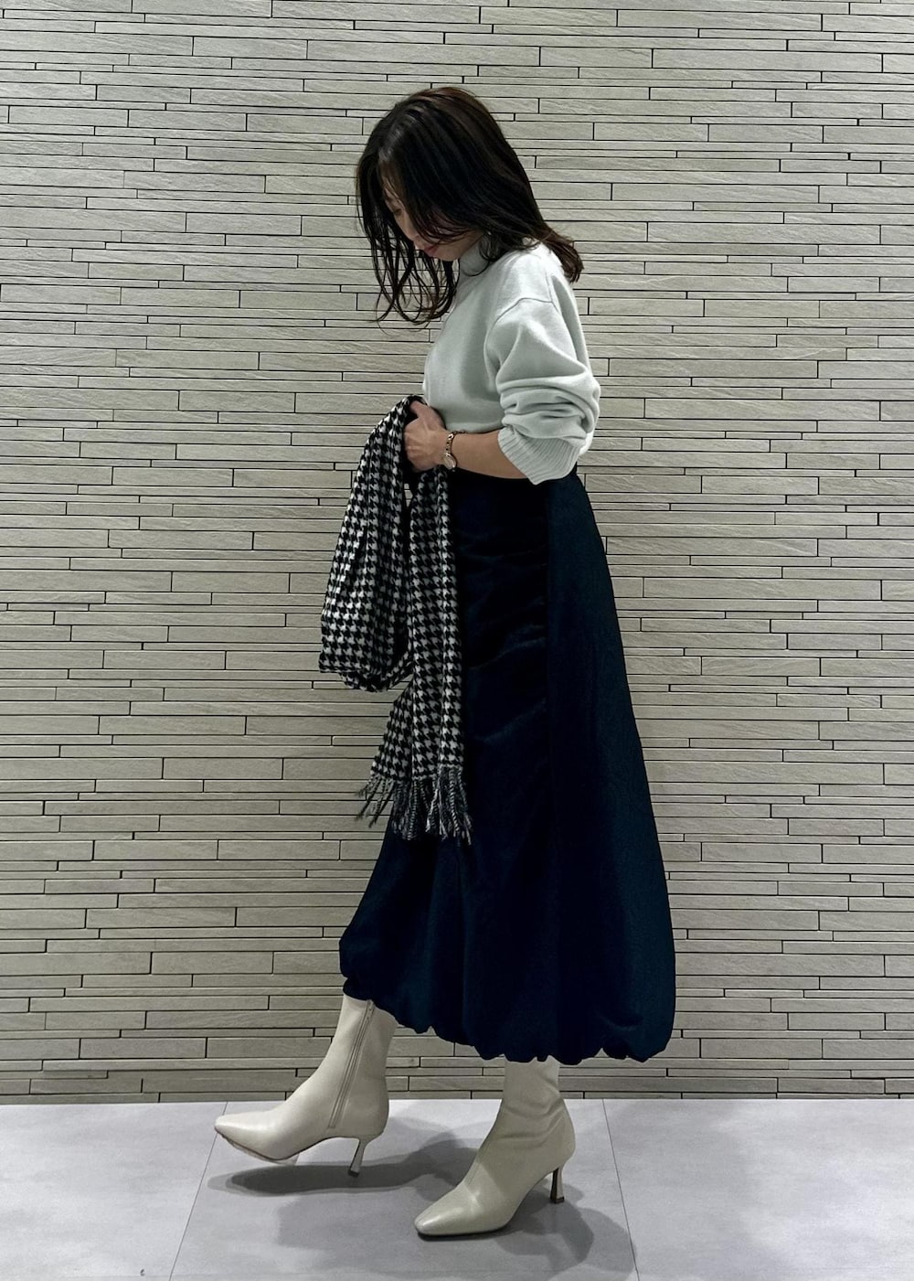 ホワイト系のブーツ、ベージュ系のショルダーバッグ、グリーン系のニット/セーターを着用したレディースの冬コーディネートの2枚目の写真