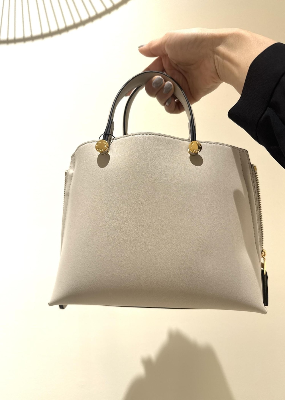 グレー系のハンドバッグ、ブルー系のワンピース、ブラック系のノーカラージャケットを着用したレディースの冬コーディネートの6枚目の写真